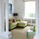 living room with green sofa cushion and floor lamp