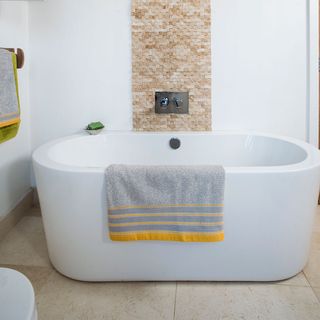 white walled bathroom with tiled flooring and stone mosaics