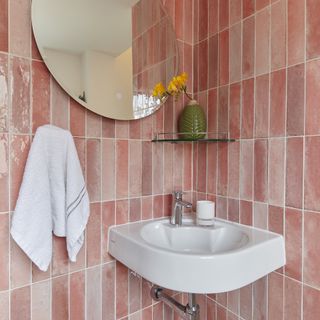 Bathroom with pink subway tiles and a white sink