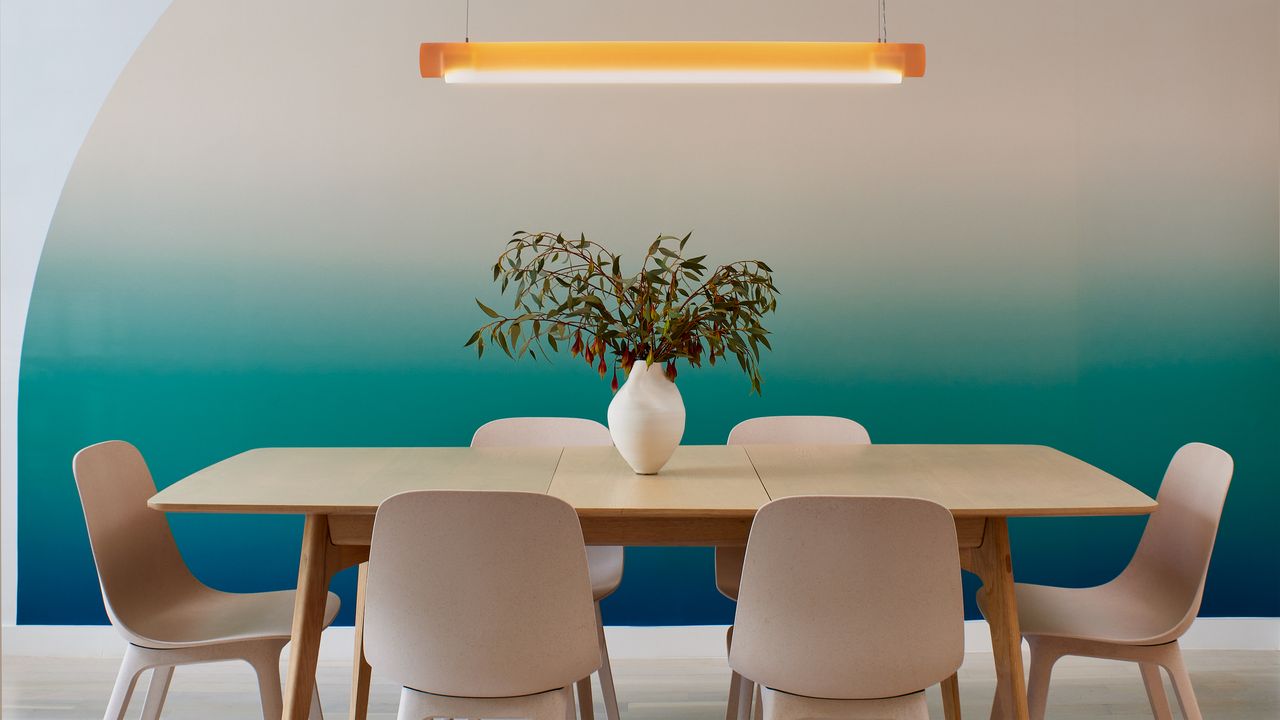 a dining room with matching table and chairs and ombre wall