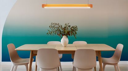 a dining room with matching table and chairs and ombre wall