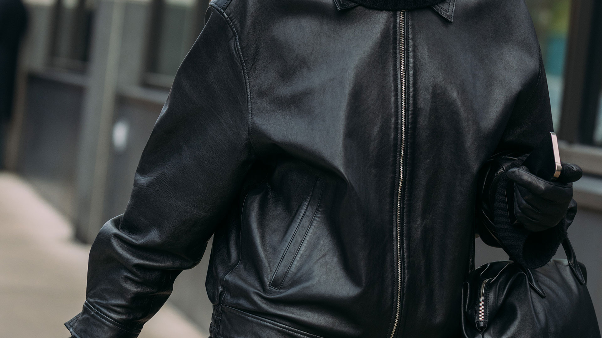 NYFW street style girl in all black, leather jacket, gloves and bag closeup shot 