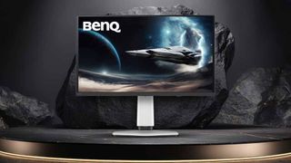 BenQ Mobiuz EX321UZ gaming monitor with spaceship on screen on metallic surface and rocks in the backdrop.