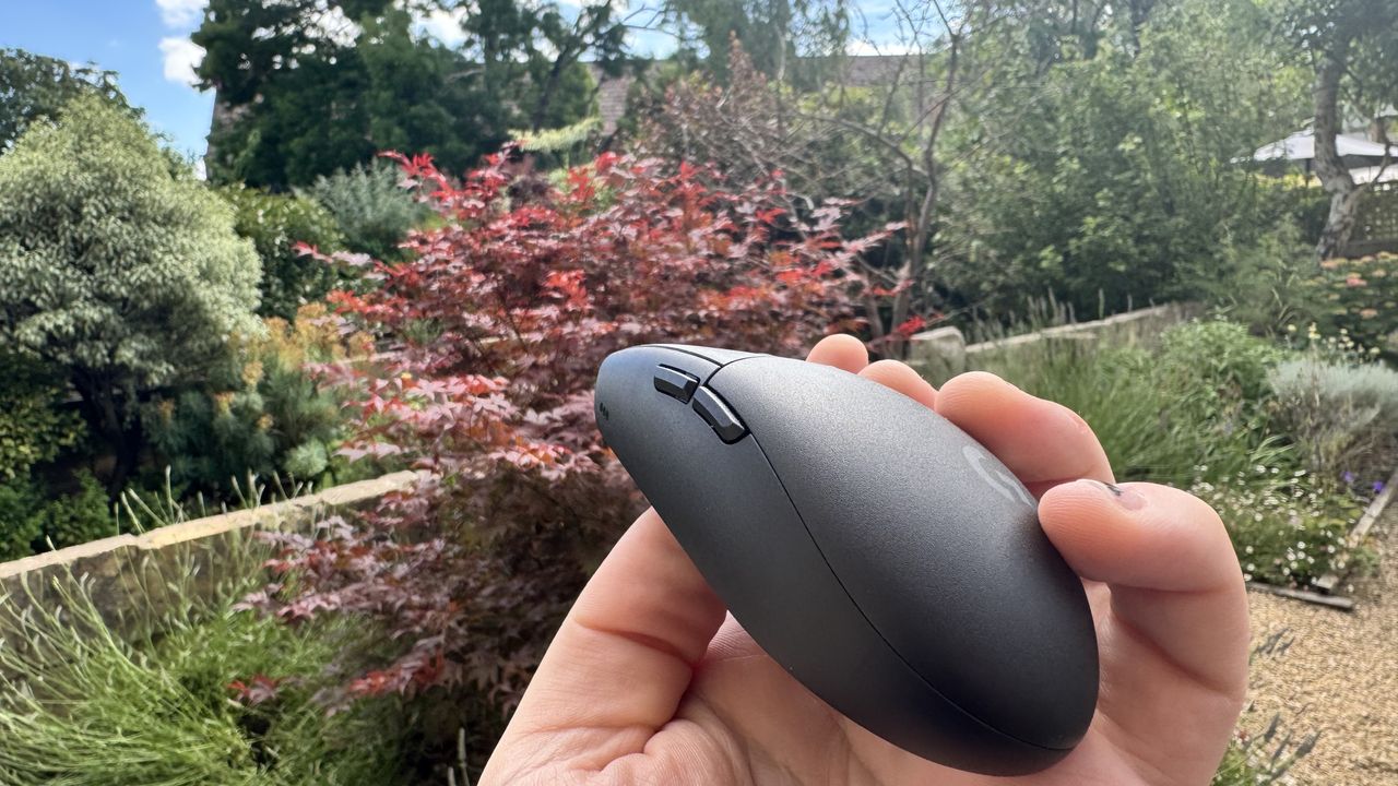 Logitech G305 X Superlight gaming mouse, held in a hand outside