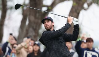 Matt Wolff strikes his tee shot and watches the flight