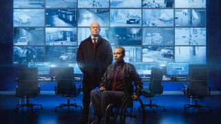 Ross Kemp as Tony stands beside Beth Alsbury in a wheelchair as Hannah in front of a bank of CCTV screens in Blindspot.