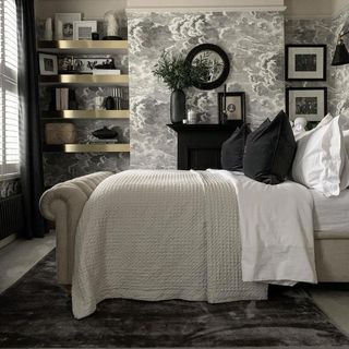 bedroom with grey designed wall bed with white and black pillow and brass shelf