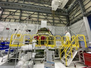 Boeing crews work on the spacecraft that will be used during the Crew Flight Test.