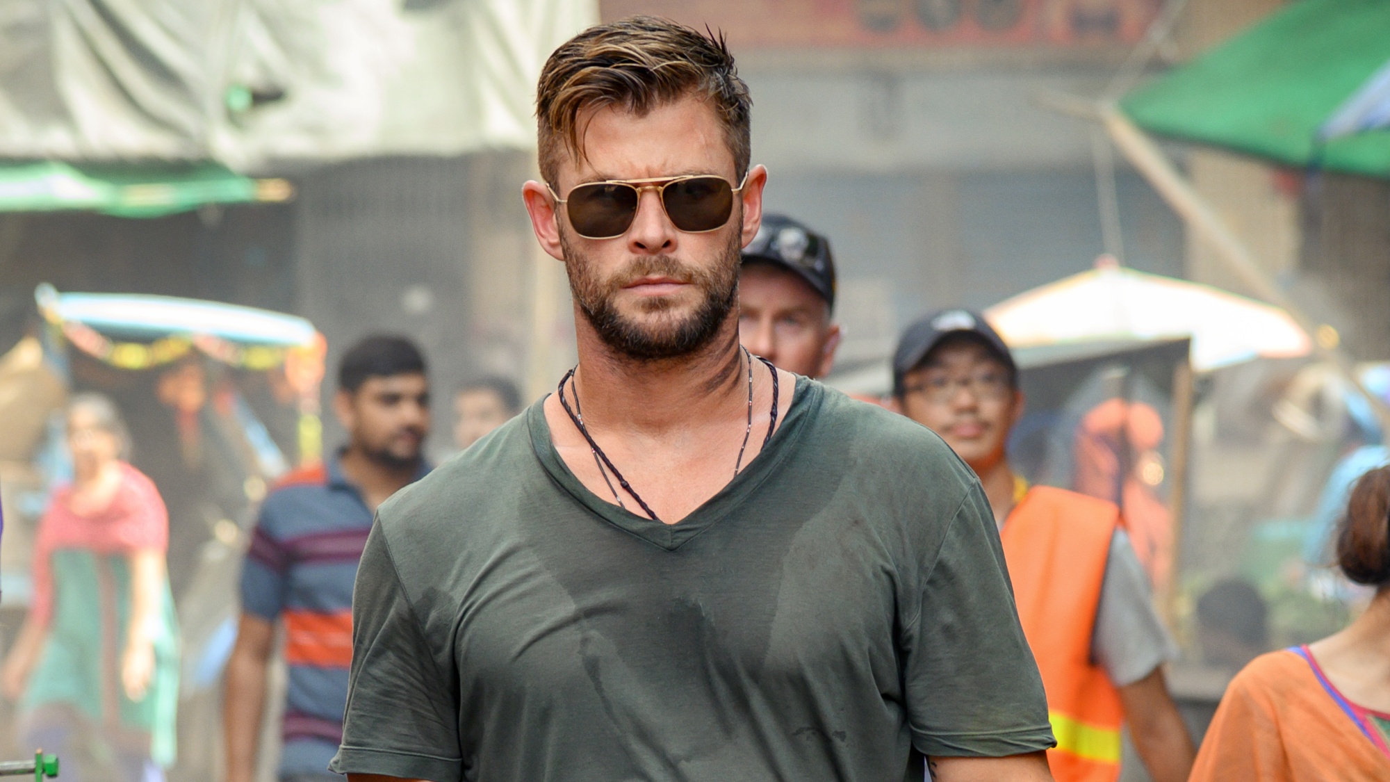 Chris Hemsworth walking down the street wearing sunglasses in Extraction.