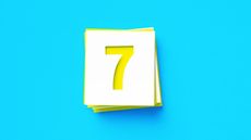 The number seven in yellow on a white sticky note against a blue background.