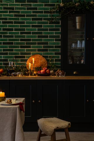 A kitchen with a countertop filled with fall elements and tall candles