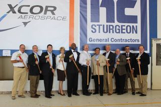 XCOR Aerospace representatives and Midland, Texas officials pose for a photo during a ceremonial wall-breaking event to mark the start of renovations on a hangar at Midland International Airport in Texas, the future home of XCOR's private Lynx space plane, on Aug. 15, 2015.