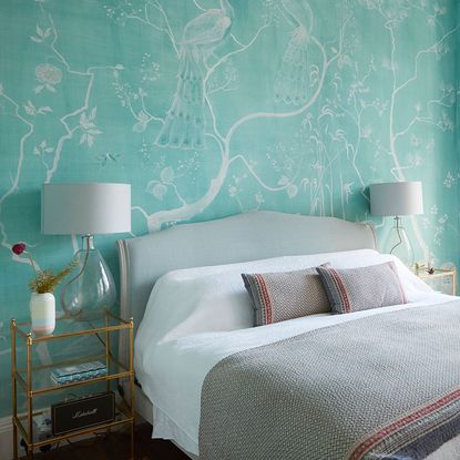 Bedroom with green patterned wallpaper and glass lamps