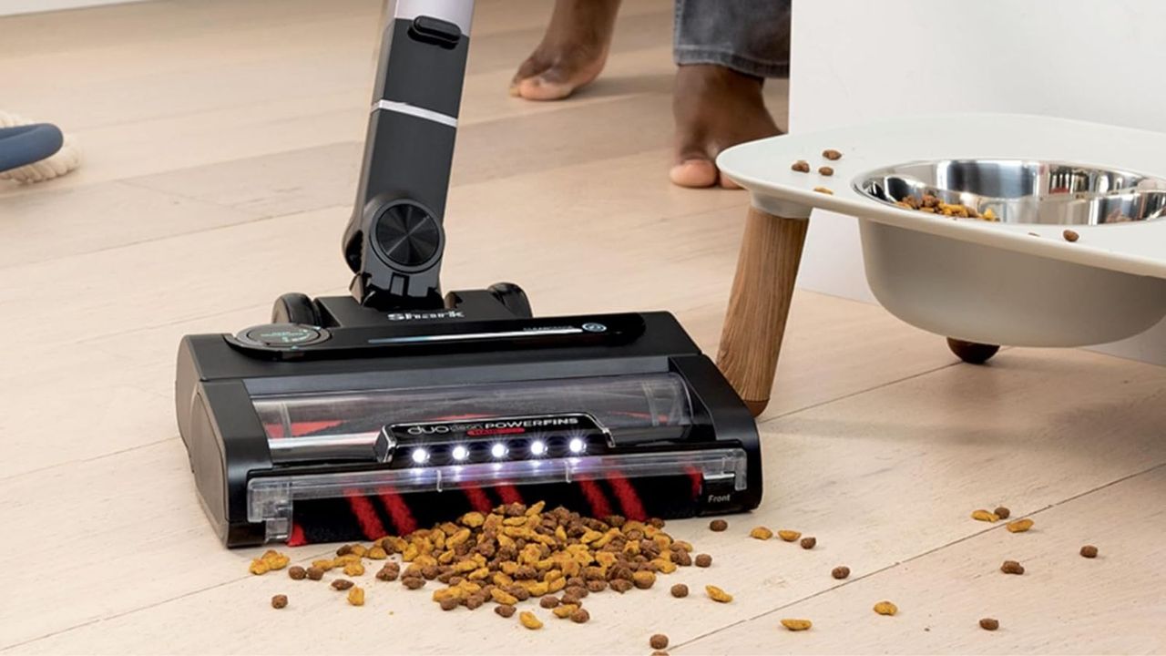 Shark Stratos vs Vertex: Shark Stratos Cordless Vacuum vacuuming kibble in front of a pet food bowl