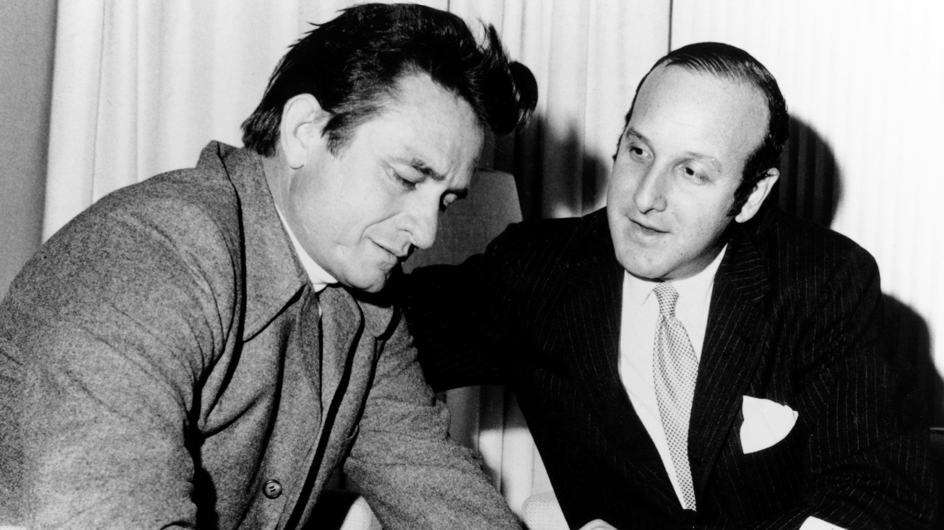 Country singer Johnny Cash signs a record contract with Columbia Records lawyer Clive Davis in circa 1960