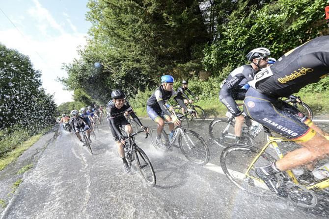 The peloton races through some flooding on the roads