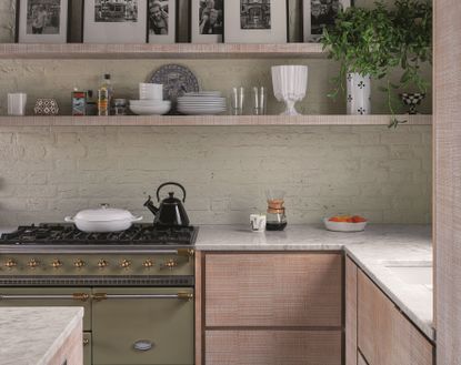 A kitchen with walls painted sage green, a large range with a Dutch oven on the stove