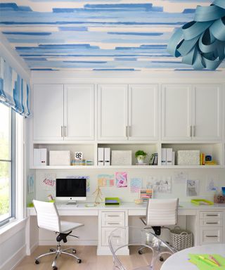 kids home office with blue wallpapered ceiling and two office chairs