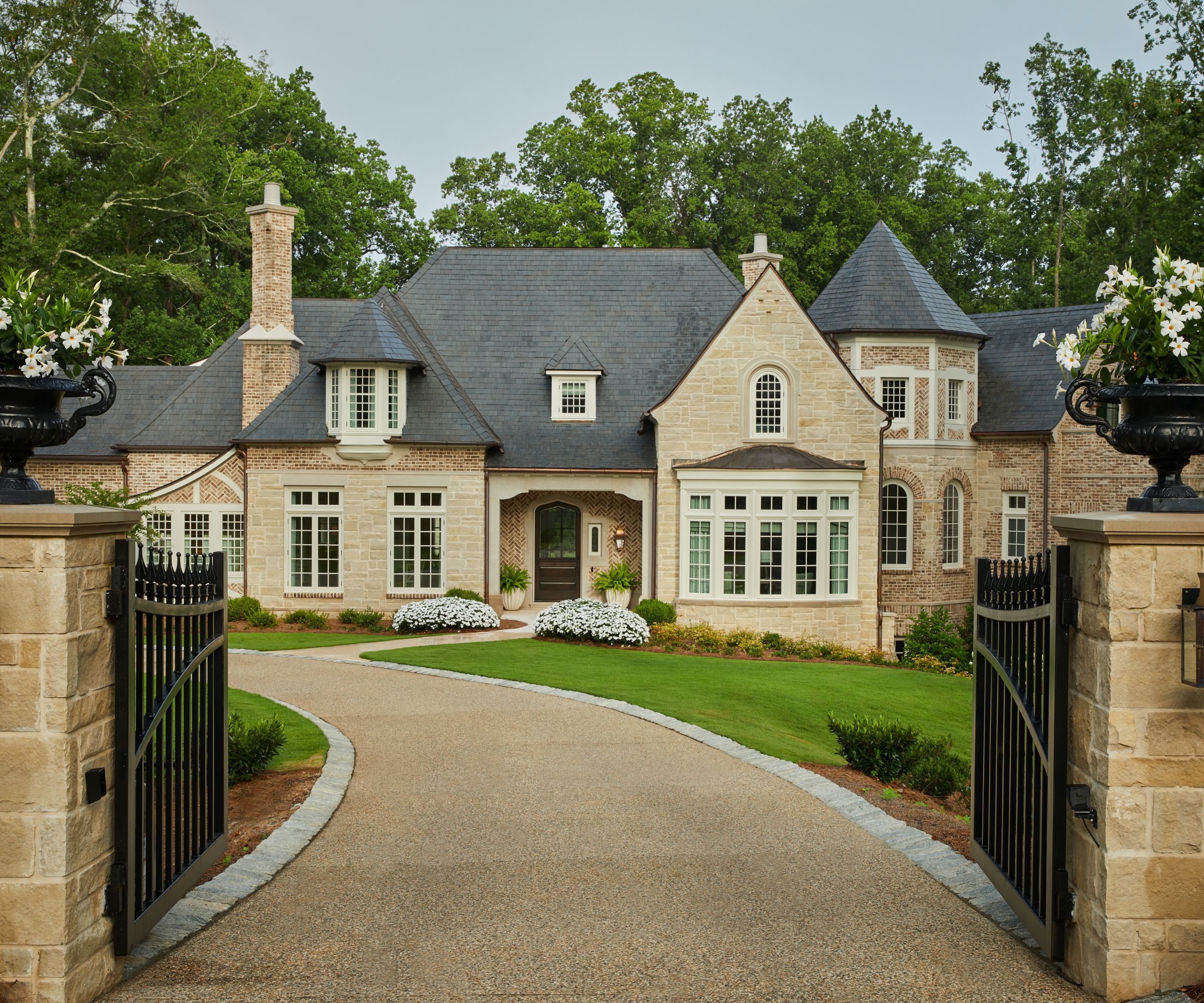 Tudor revival style house with curved driveway and large gates