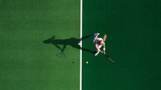 Bird's eye view of woman in whites playing tennis for longevity
