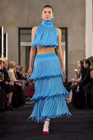 An Alaïa model wearing an electric blue textured two-piece.