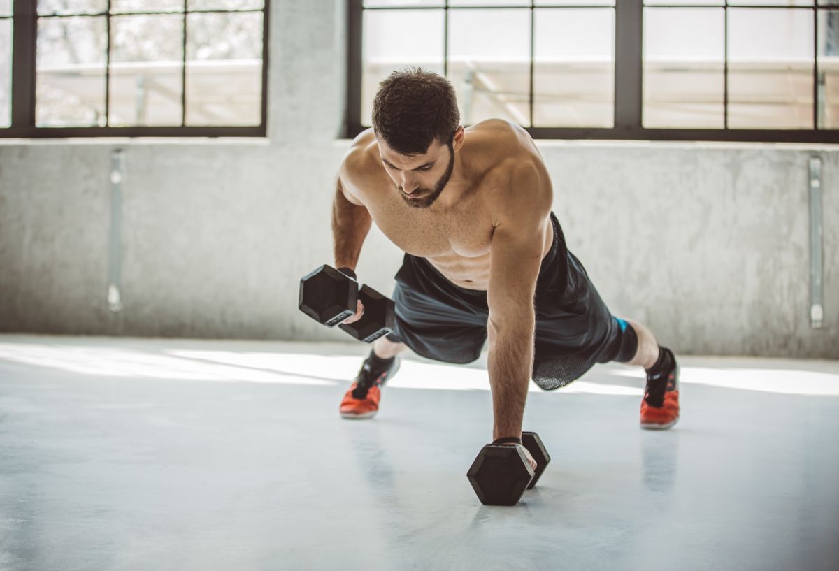 Man performing a renegade row push up with dumbbell