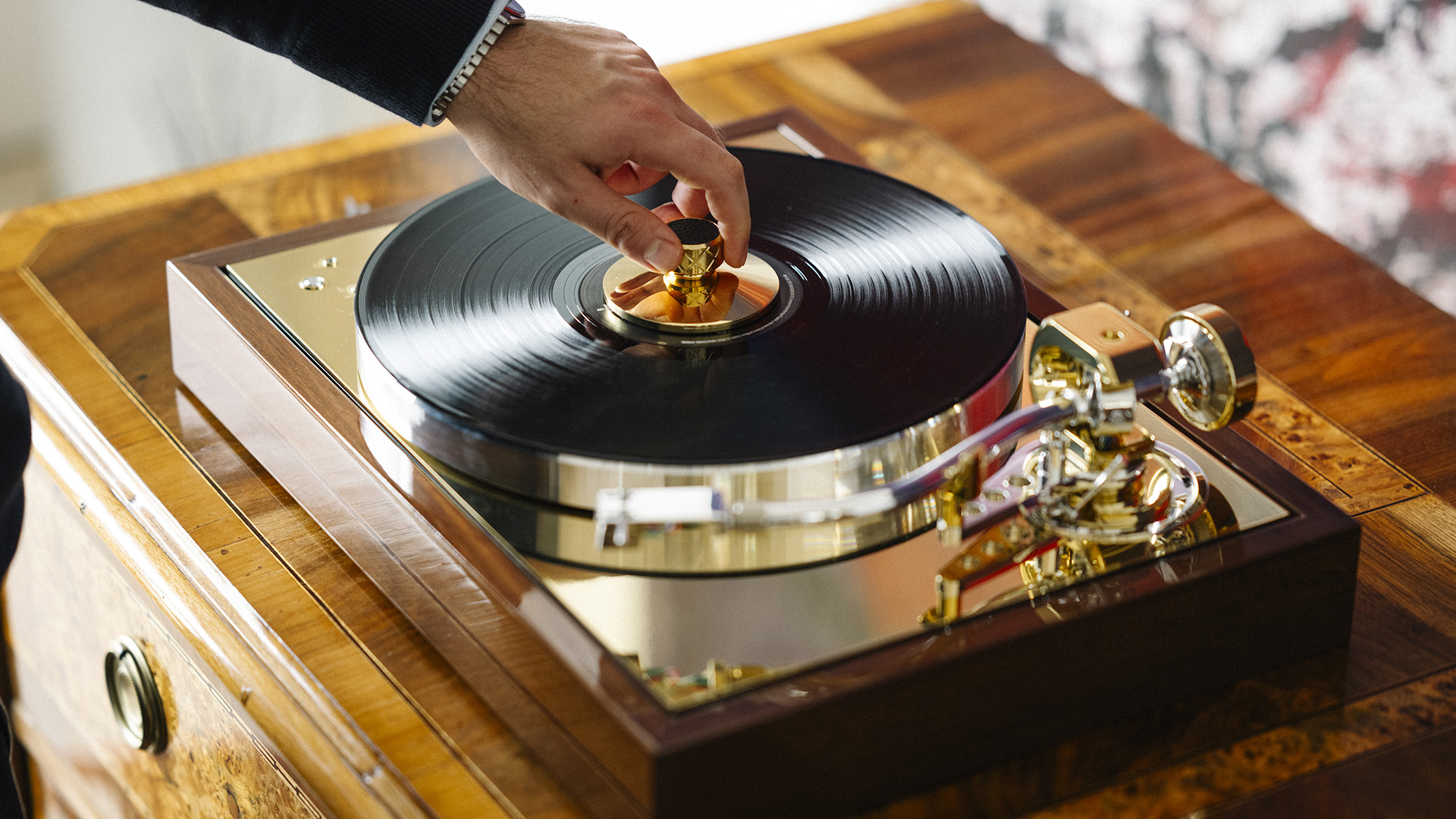 Pro-Ject Classic Reference on sideboard with man placing a record weight on top of the vinyl