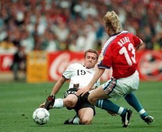 Germany's Thomas Strunz slides in to win the ball ahead of Czech Republic midfielder Radek Bejbl in the final of Euro 96.