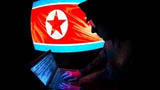 North Korean Officer is hacking on a laptop. 