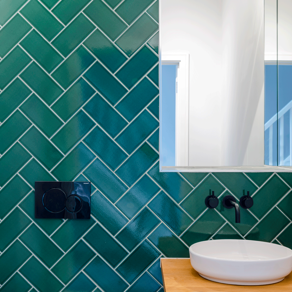 bathroom with green tiles and white sink