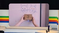 Google Gemini's Project Astra says "Schrodinger's Cat" while looking at two drawn cats and a box with a question mark on it