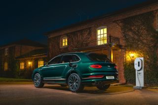 Bentley Bentayga Hybrid outside a house at night being charged