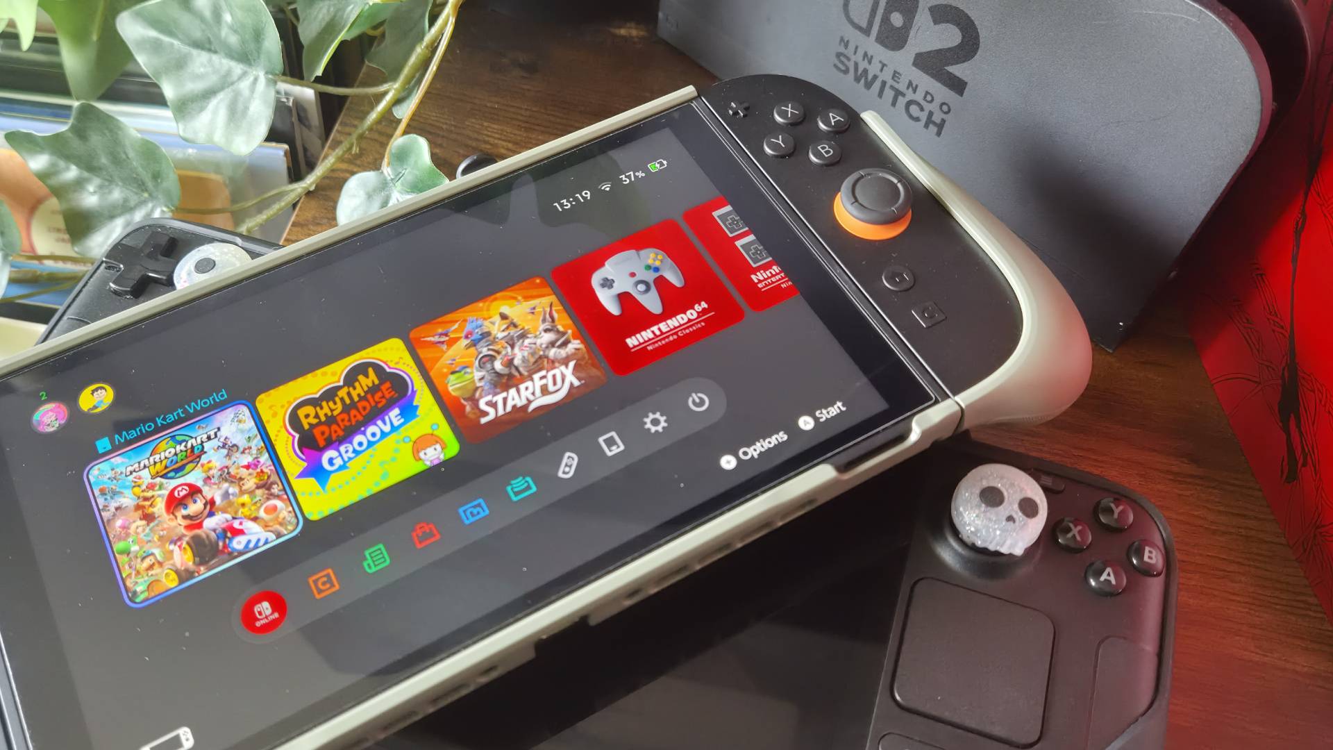 Photo of the Belkin Charging Grip attached to a Switch 2 sitting on a Steam Deck OLED.