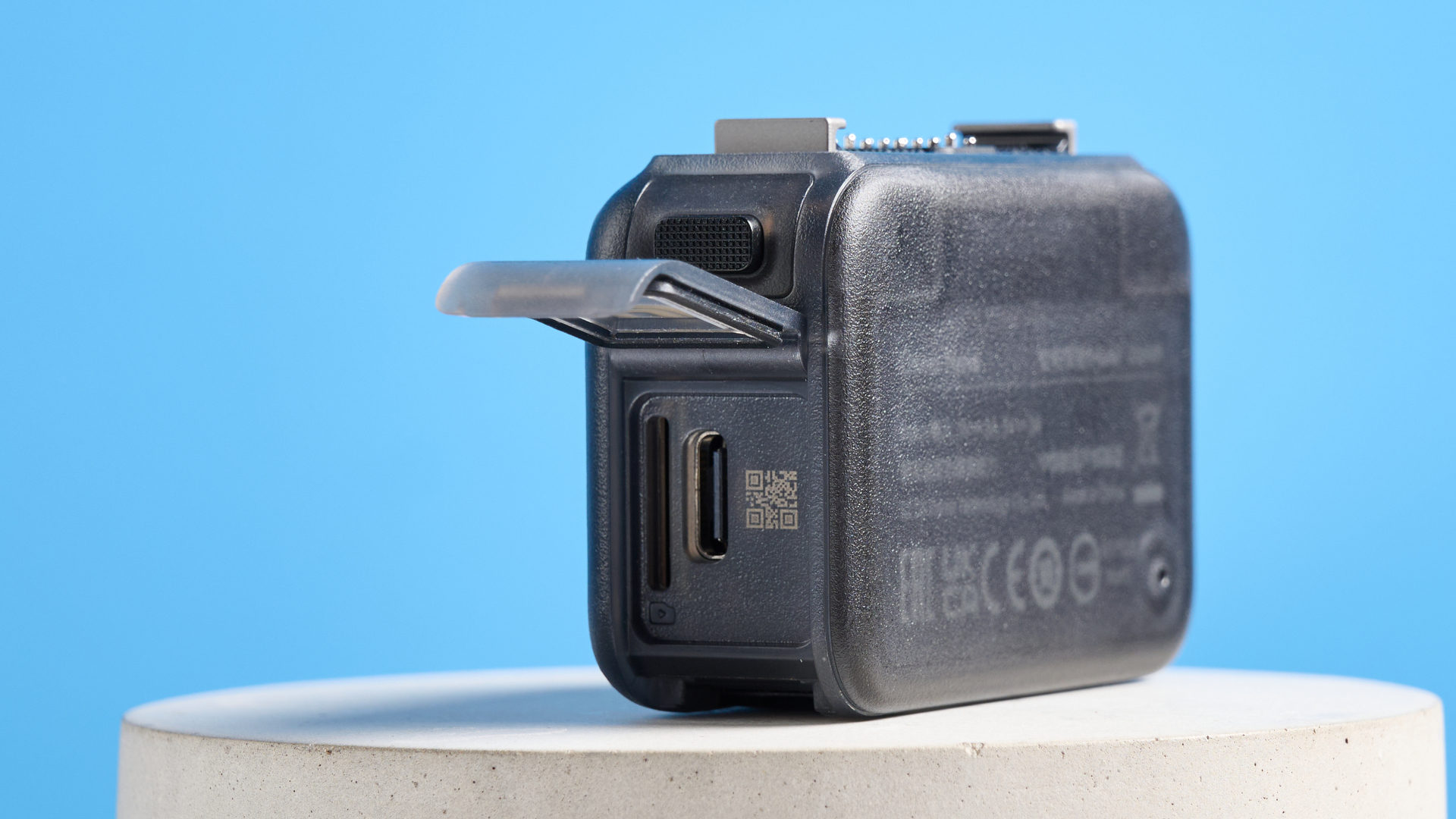 DJI Osmo Nano with its side hatch open against a blue background