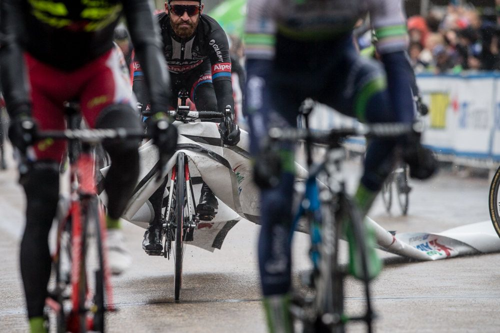 Simon Geschke (Giant-Alpecin) gets tangled up in a finishing banner after finishing the stage