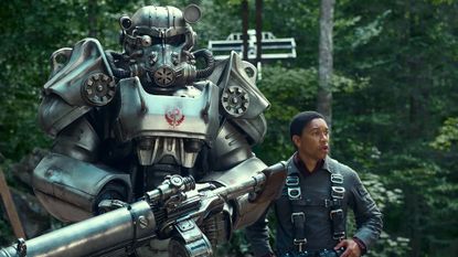 Maximus standing next to a suit of power armor