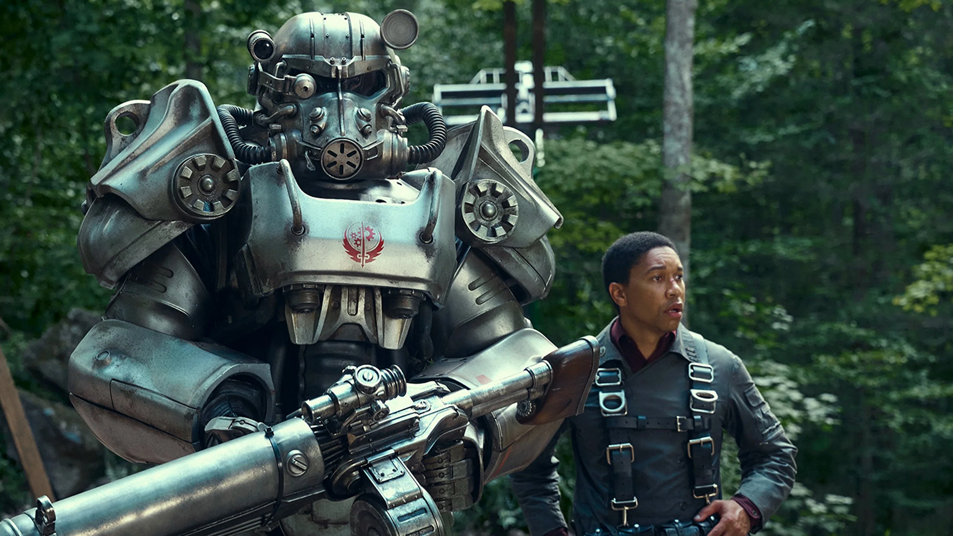 Maximus standing next to a suit of power armor