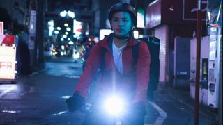 Young man on bike with glaring front light