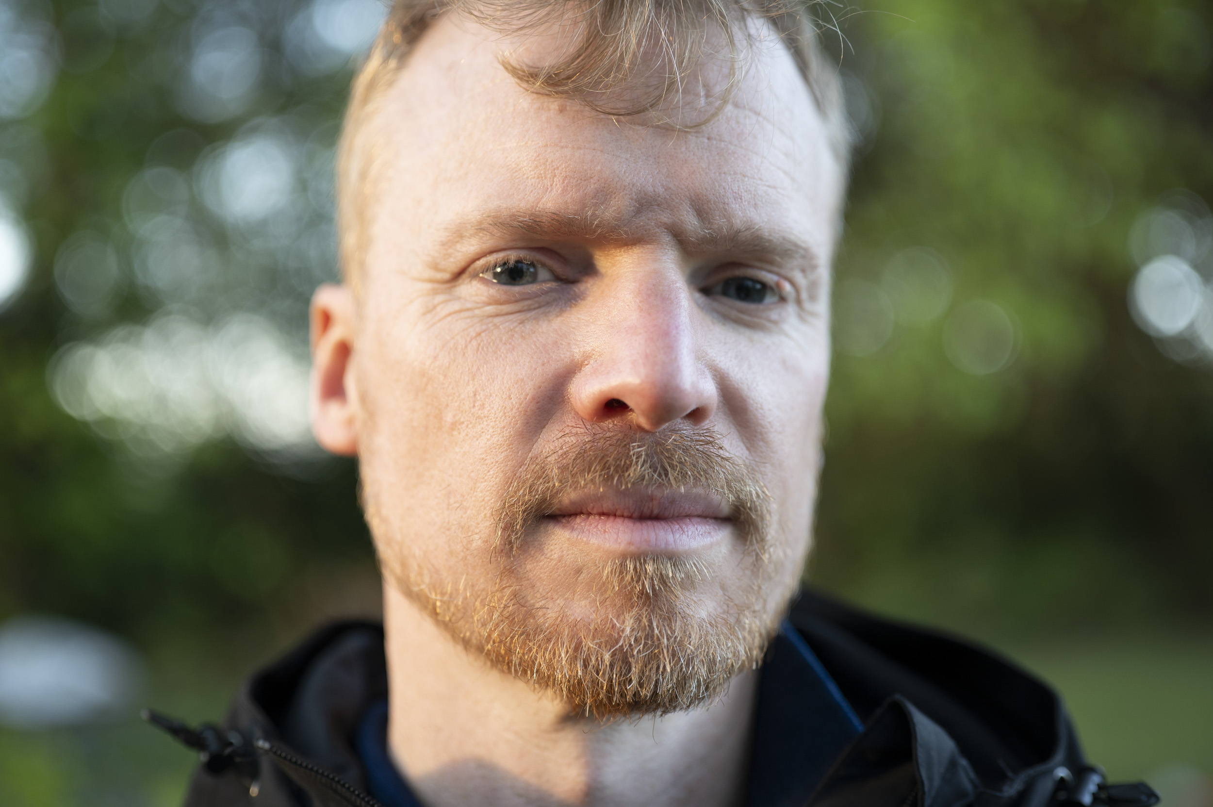 Portrait of a man during golden hour with dappled light through trees, taken with the Viltrox AF 50mm F2 Air lens