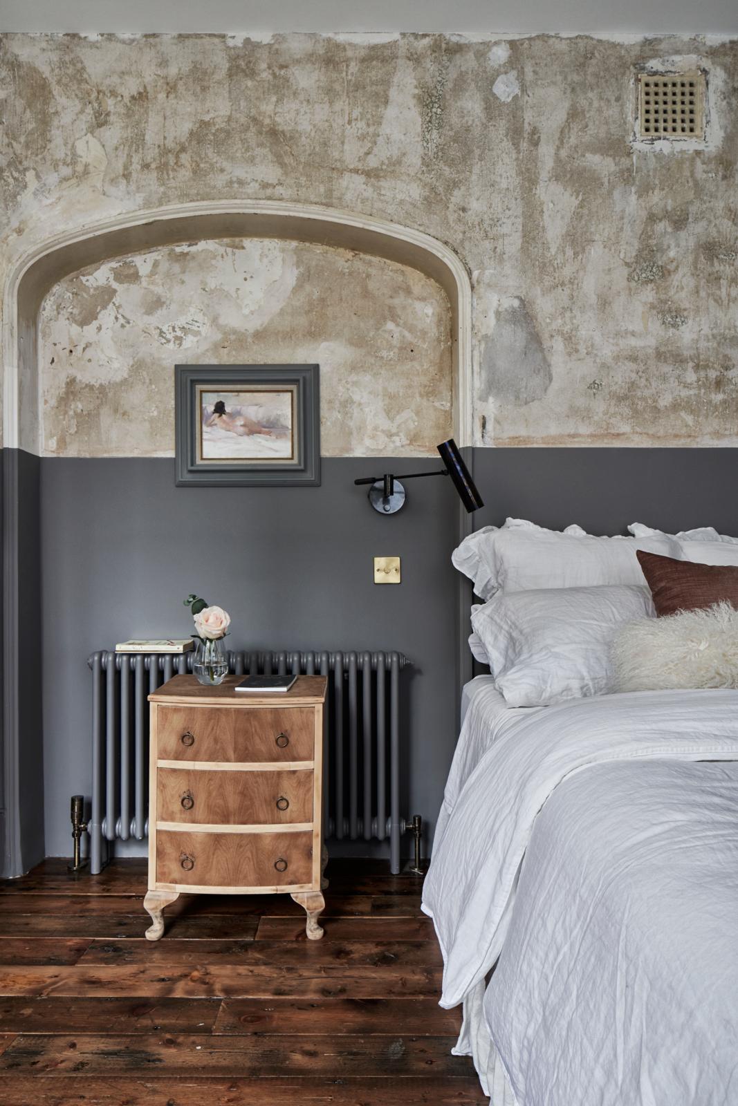 Grey bedroom with half distressed wall