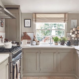 kitchen with cream shaker-style cabinetry and linen roman blind