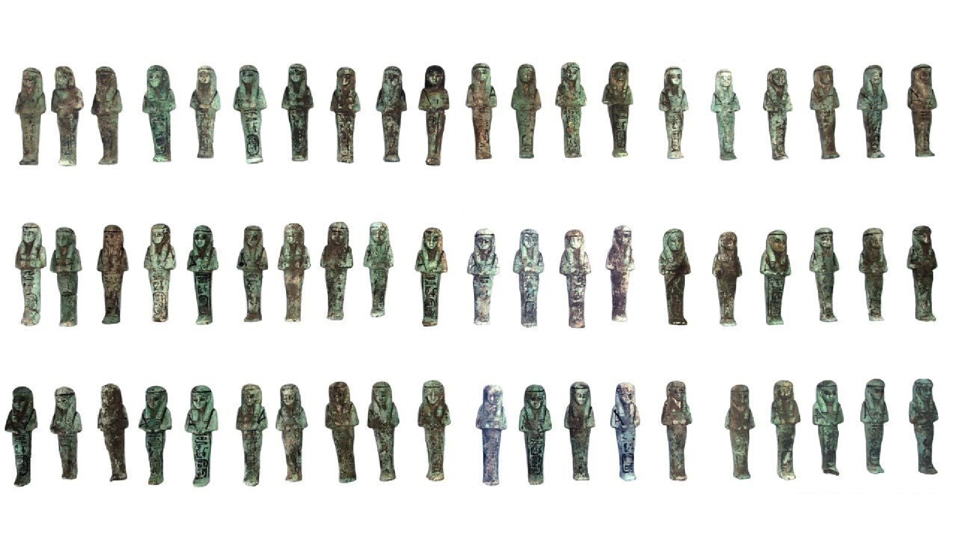 Dozens of shabti figurines lined up against a white background