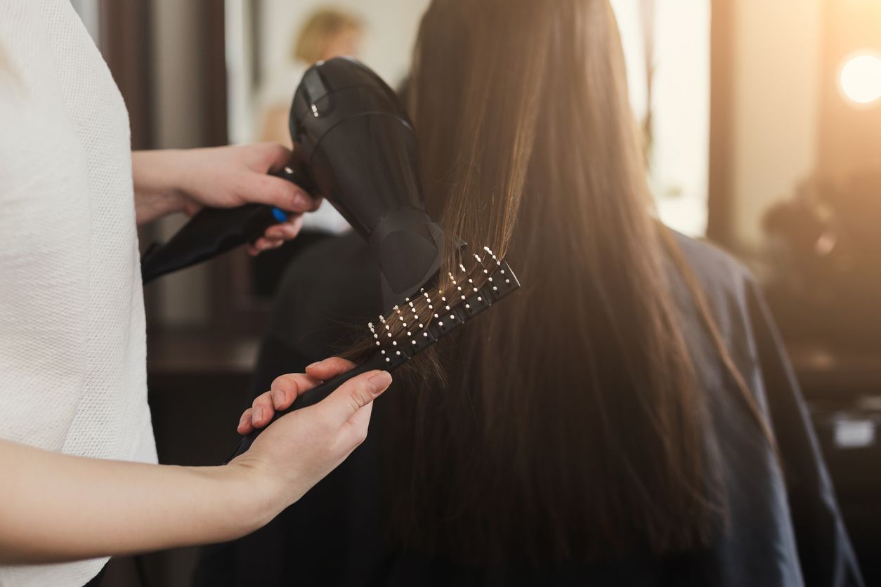 A woman gets her hair styled.