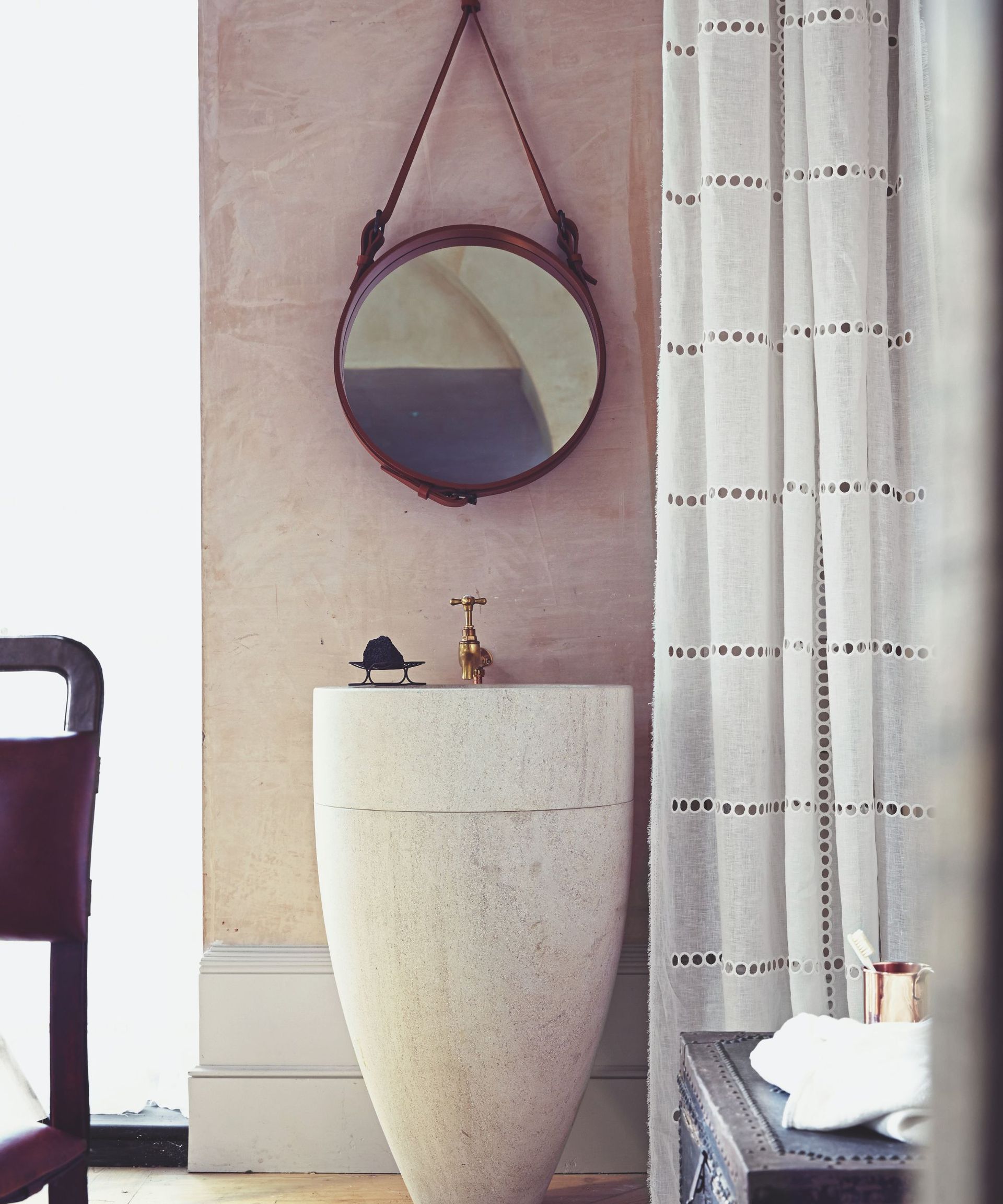 A plaster pink bathroom with a statement sink