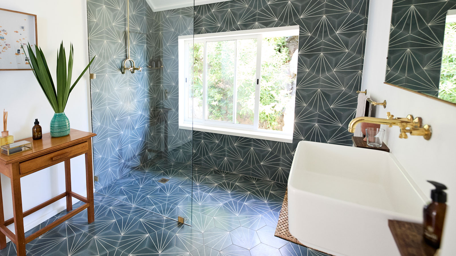 Dark hexagon tiles on wall and floor in shower room with bathroom furniture in the foreground