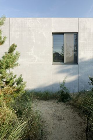 Side view of the concrete walls and window of the house