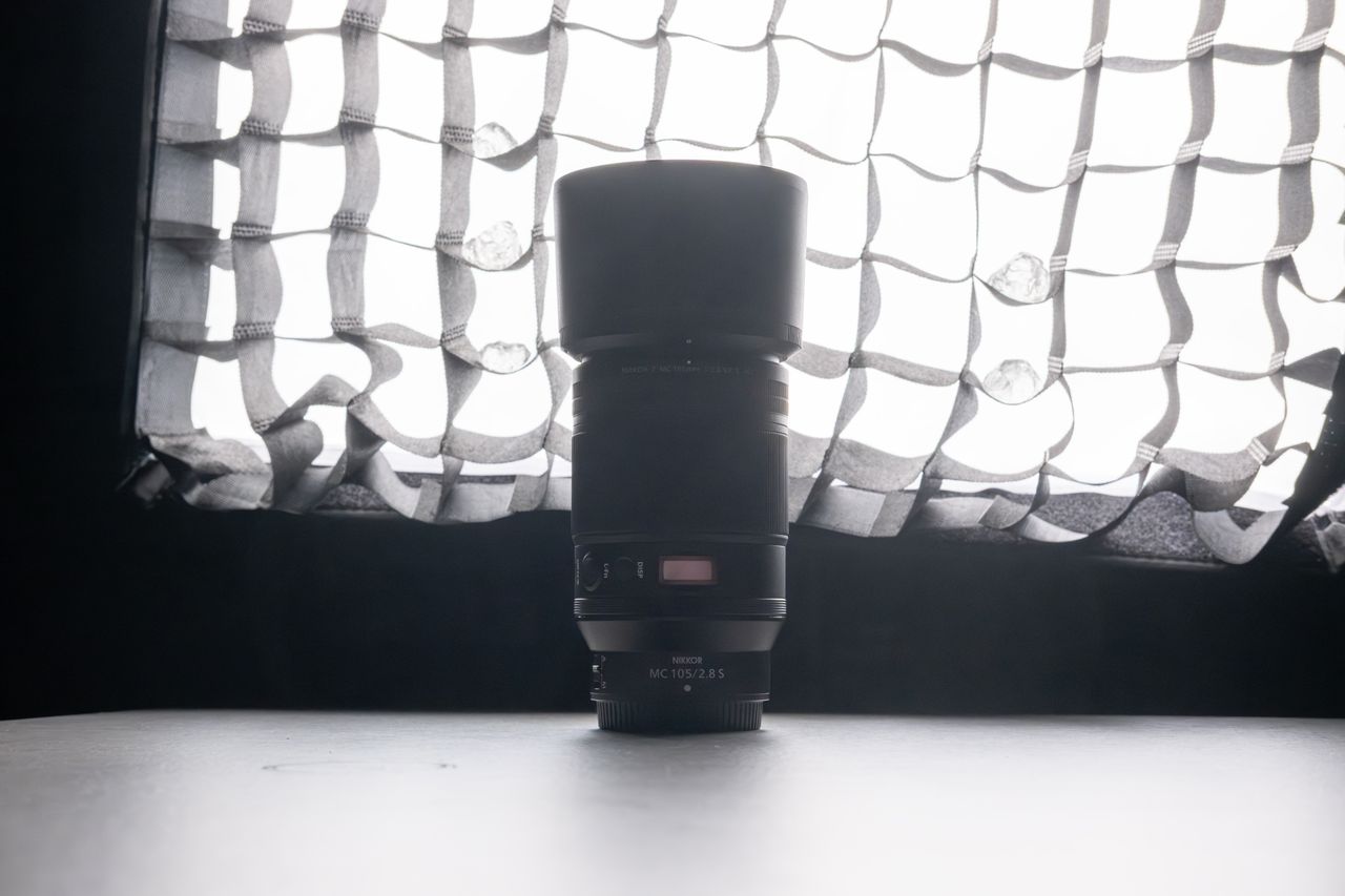 A backlit photo of a Nikon lens in front of a lit softbox, brightened in post production.