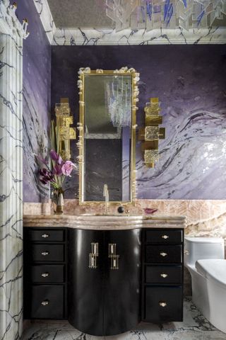 A grand purple bathroom featuring marble and gold