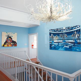 upstairs hallway with blue wall and wooden floor