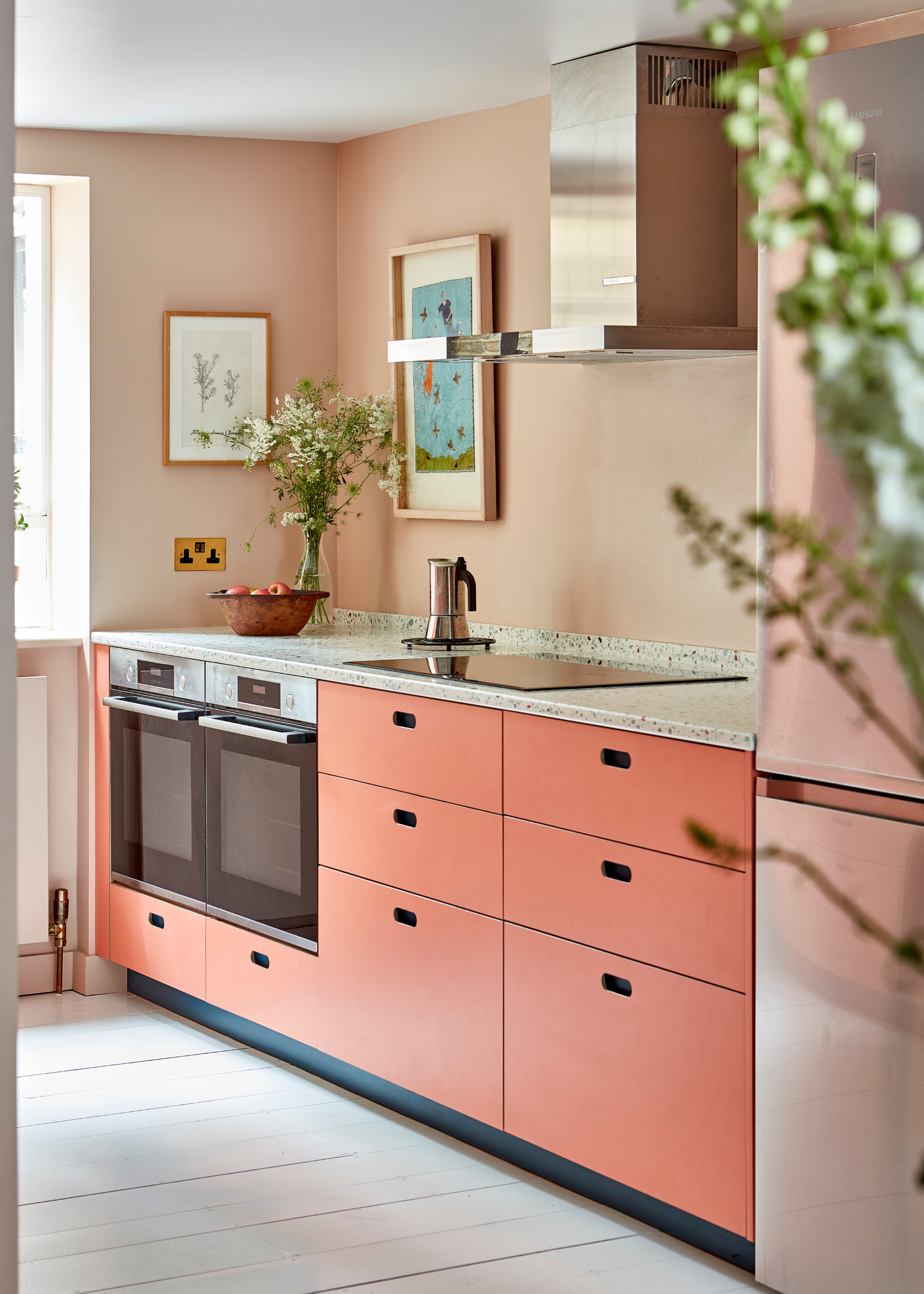 bright coral cabinets with soft pink walls in a small kitchen